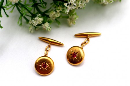 Botões de punho em ouro amarelo com rubis lapidados no centro.